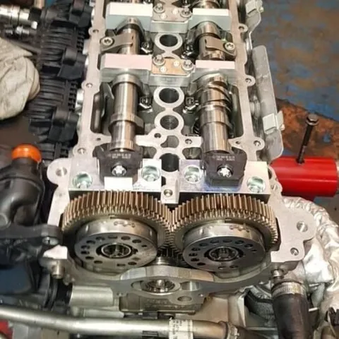 Cylinder head on the bench with twin camshafts, bearing caps and a pair of cam gears fitted