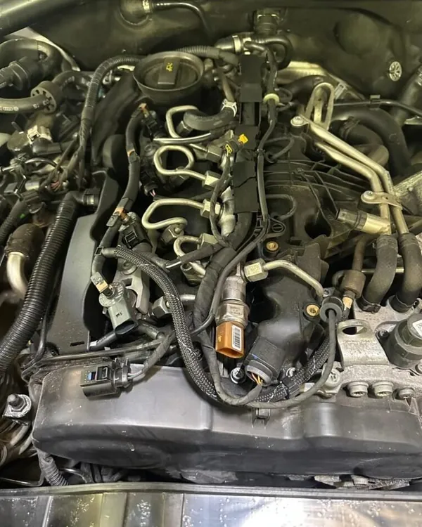 Diesel engine with the top cover removed, showing the fuel injector lines, sensors and wiring loom during fault finding