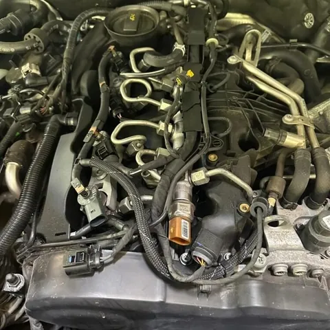 Diesel engine with the top cover removed, showing fuel injector lines, sensors and the wiring loom