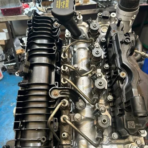 Top of a diesel engine on a workshop stand, showing the injectors, high-pressure fuel pipes and inlet manifold