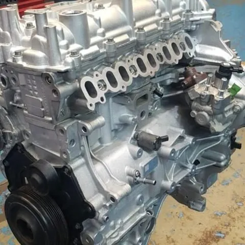 Rebuilt engine on a stand seen from the crankshaft pulley end, with the inlet ports and fuel pump visible